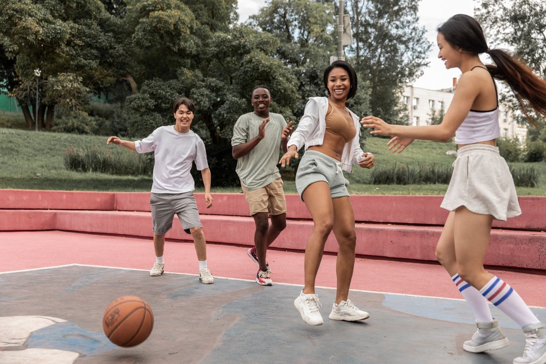 Friends enjoying a casual game of basketball on an outdoor court